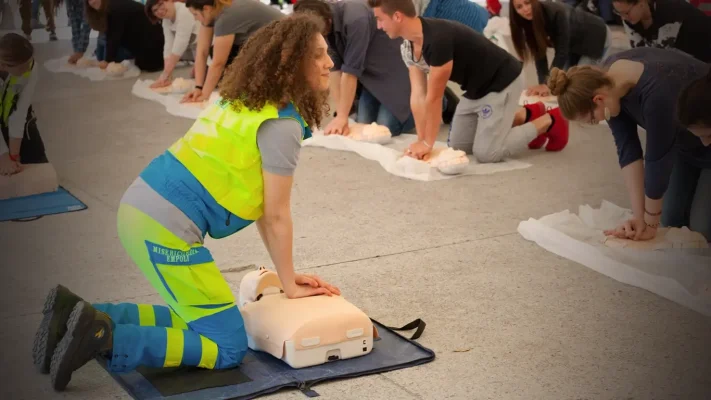 Femme expliquant la réalisation d’un massage cardiaque lors d’un atelier Santé, Sécurité et Prévention au Luxembourg – formation, prévention et team building teambuildings.lu